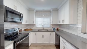 El Cajon apartment for rent - a renovated kitchen with white cabinets and stainless steel appliances