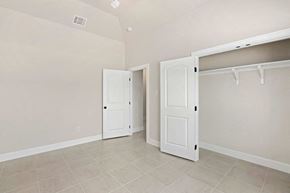 Hondo house for rent - a bedroom with two closets and two doors and a tiled floor