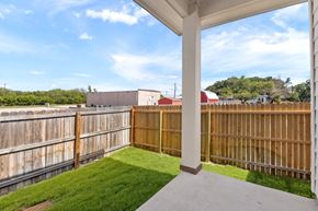 Hondo house for rent - the backyard of a house with a wooden fence and grass