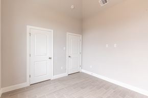 Hondo house for rent - an empty bedroom with two doors and a tiled floor