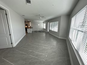 Bradenton house for rent - a large living room with a large window and a ceiling fan