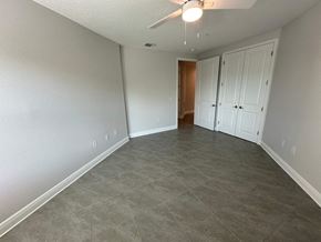 Bradenton house for rent - an empty living room with tile flooring and a ceiling fan