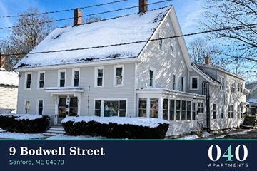 Sanford apartment for rent - A white house with snow on the roof and a sign that says 040 Apartments.