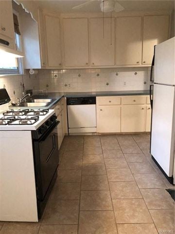 Montgomery house for rent - a kitchen with white cabinets and a stove and a refrigerator