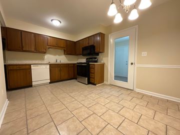 Winston Salem apartment for rent - A kitchen with brown cabinets and a white dishwasher.