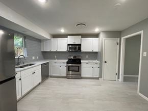 Killeen house for rent - A kitchen with white cabinets and a black refrigerator.