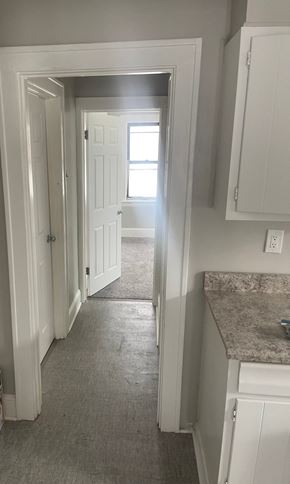 Akron apartment for rent - A hallway with white doors and a granite counter.