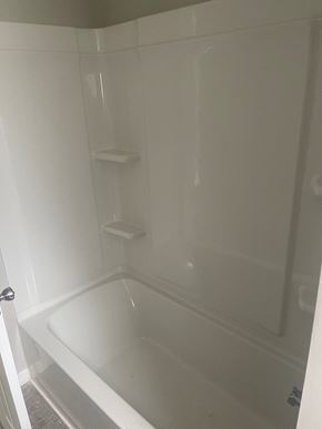 Akron apartment for rent - A white bathroom with a tub and a toilet paper holder.
