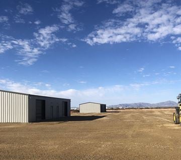El Paso house for rent - two buildings in the middle of a dirt field with a blue sky