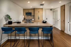 San Diego apartment for rent - kitchen with wooden cabinets and blue barstool chairs