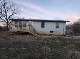 Calhoun house for rent - a small house in a field with a wooden deck