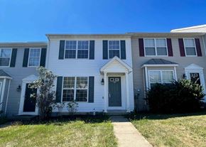Winchester townhouse for rent - A white house with a grey roof and a green lawn in front.