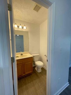 Winchester townhouse for rent - A bathroom with a toilet, sink, and mirror.