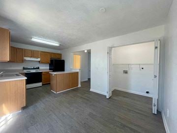 Winchester townhouse for rent - A kitchen with wooden cabinets and a black fridge is visible.