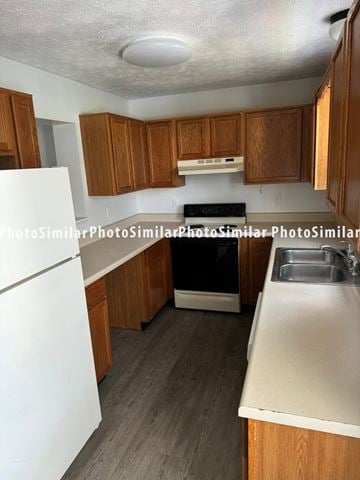 Winchester townhouse for rent - a kitchen with wood cabinets and white counter tops and a black stove