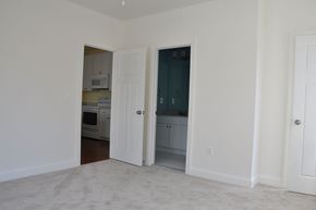 Winchester apartment for rent - A white room with a carpet floor and two doors, one open.