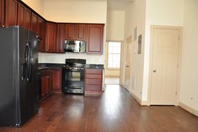 Winchester apartment for rent - an empty kitchen with black appliances and wooden floors