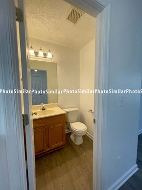 Winchester townhouse for rent - A bathroom with a toilet, sink, and mirror.