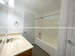 Winchester townhouse for rent - A white bathroom with a sink, mirror, and bathtub.