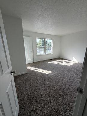 Winchester townhouse for rent - A room with a carpeted floor and a window letting in sunlight.
