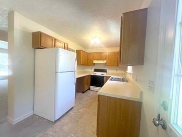 Winchester townhouse for rent - A kitchen with a white refrigerator and wooden cabinets.