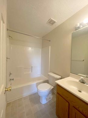 Winchester townhouse for rent - A white bathroom with a toilet, sink, and bathtub.