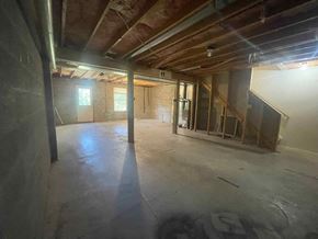 Winchester townhouse for rent - an unfinished basement with exposed beams and a staircase