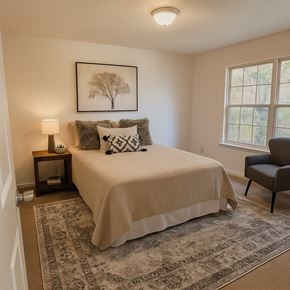 Winchester townhouse for rent - A bedroom with a bed, a chair, and a framed picture of a tree on the wall.