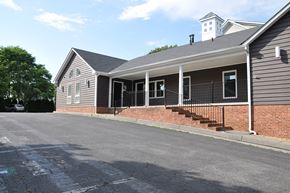 Winchester apartment for rent - A grey house with a black iron fence and a brick wall.