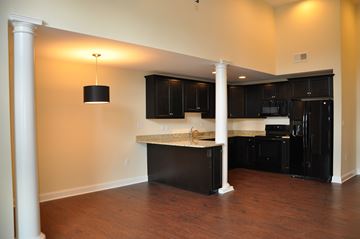 Winchester apartment for rent - a kitchen with black cabinets and an island in the middle of a room