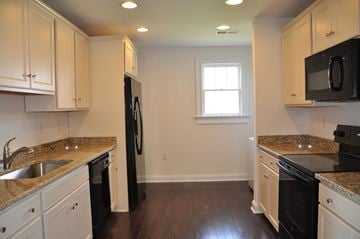 Winchester apartment for rent - A kitchen with black appliances and white cabinets.