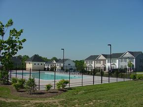 Winchester townhouse for rent - A pool surrounded by a black fence and a few trees.