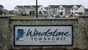 Winchester townhouse for rent - a sign for windstone townhomes in front of some houses