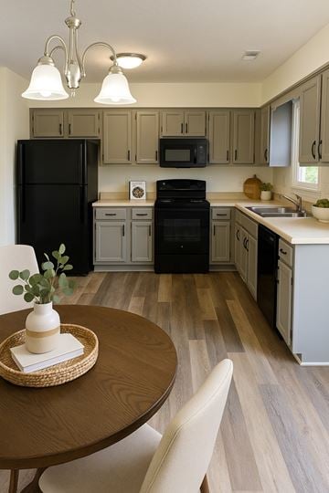 Winchester townhouse for rent - A black refrigerator is in the corner of a kitchen with wooden floors.