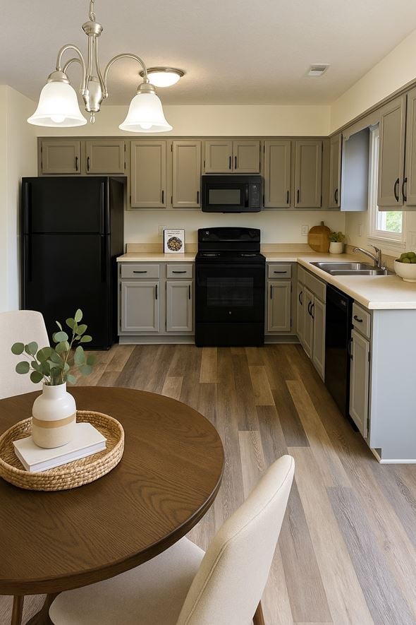 Winchester townhouse for rent - A black refrigerator is in the corner of a kitchen with wooden floors.