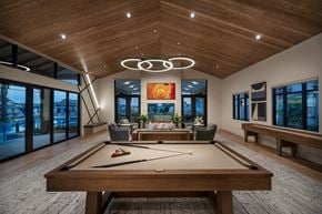 Surprise apartment for rent - a pool table in the center of a large room with windows