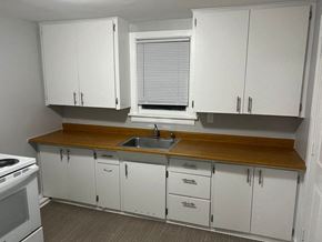 Wahpeton apartment for rent - A kitchen with white cabinets and a wooden countertop.