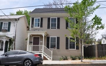 Winchester apartment for rent - A grey house with a car parked in front.