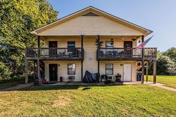 Bowling Green apartment for rent - A two-story house with a balcony and an American flag.