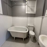 Poughkeepsie apartment for rent - A white toilet sits next to a white bathtub in a bathroom.