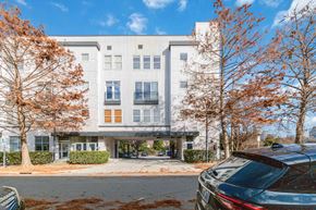Charlotte apartment for rent - A grey building with a car parked in front.
