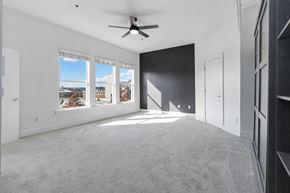 Charlotte apartment for rent - A spacious room with a ceiling fan and large windows overlooking a residential area.