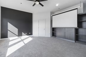 Charlotte apartment for rent - A room with a ceiling fan and a large white screen on the wall.