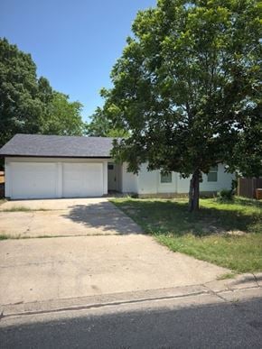 Austin house for rent - A tree is in front of a white house.
