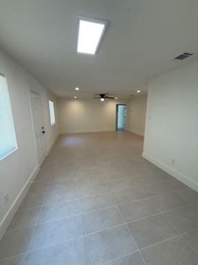 Austin house for rent - A spacious room with a skylight and a ceiling fan.