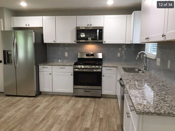 Killeen house for rent - A kitchen with white cabinets and a granite countertop.