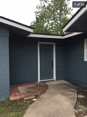 Killeen house for rent - A blue house with a white door and a concrete walkway.