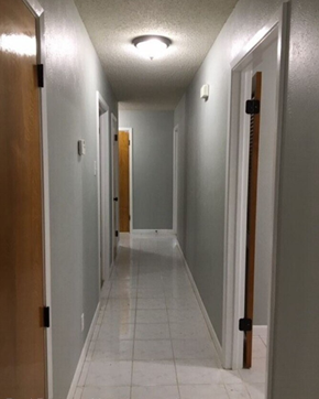 Temple house for rent - a long hallway with doors and a white tile floor and a ceiling light