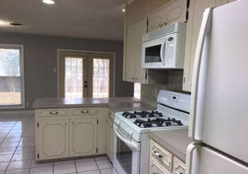 Temple house for rent - a white kitchen with a stove and a microwave