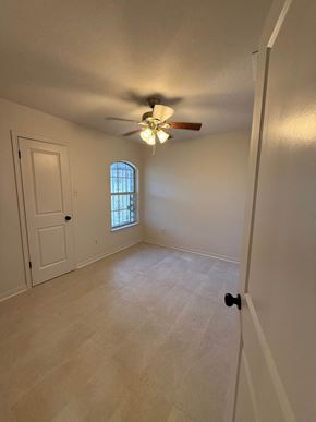 Killeen house for rent - an empty living room with a ceiling fan and a window